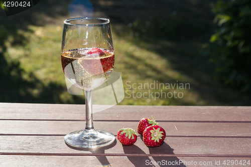 Image of Backlit glass with sparkling wine and strawberries