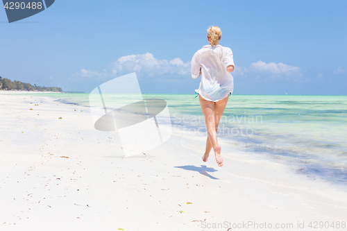 Image of Happy woman having fun, enjoying summer, running joyfully on tropical beach.