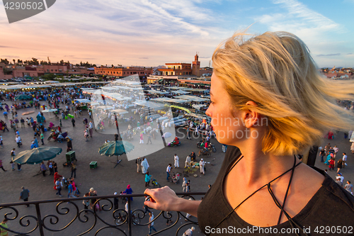 Image of Woman overlooking Jamaa el Fna market square in sunset, Marrakesh, Morocco, north Africa.