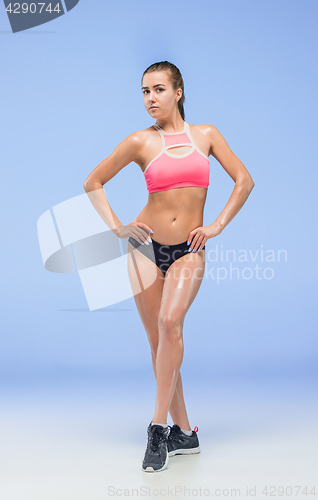 Image of Muscular young woman athlete posing at studio