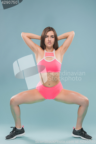 Image of Muscular young woman athlete posing at studio