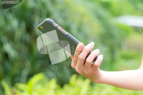 Image of Young woman using cellphone outdoor