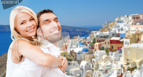 Image of happy couple hugging over santorini island