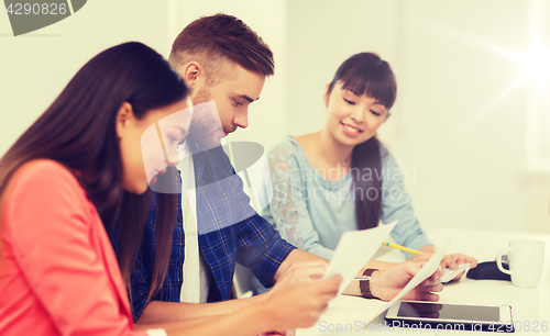 Image of happy creative team or students working at office