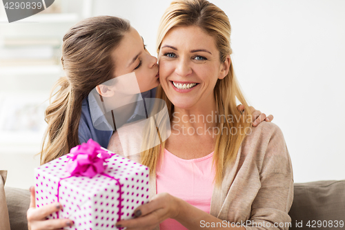 Image of girl giving birthday present to mother at home