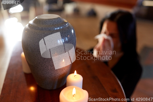 Image of woman with cremation urn at funeral in church