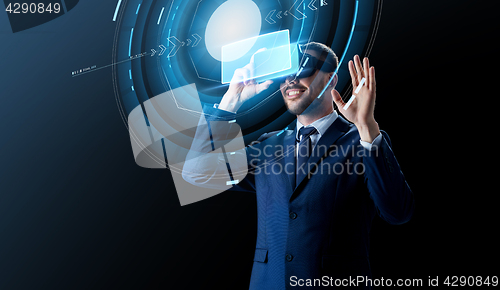 Image of businessman in virtual reality headset over black