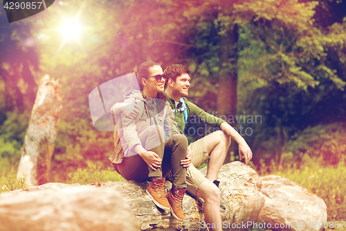 Image of smiling couple with backpacks in nature