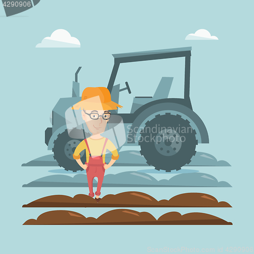 Image of Farmer standing with tractor on background.