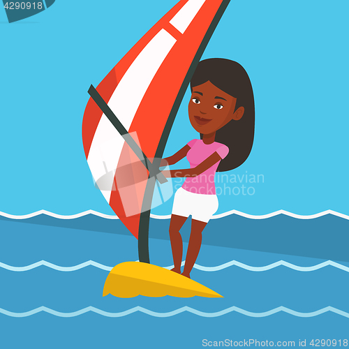 Image of Young woman windsurfing in the sea.