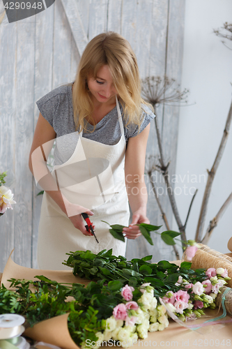 Image of Young girl florist makes bouquet