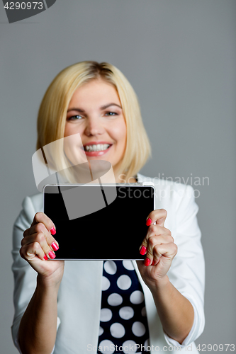 Image of Smiling beautiful model holds tablet