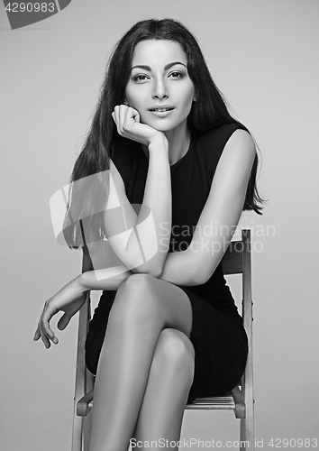 Image of The colorless portrait of business woman sitting on chair in studio