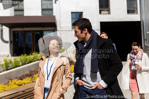 Image of people with coffee and conference badges in city