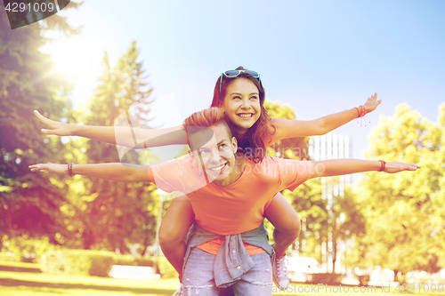 Image of happy teenage couple having fun at summer park