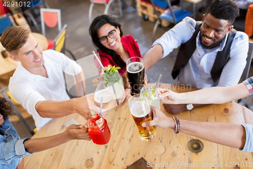 Image of friends clinking glasses with drinks at restaurant
