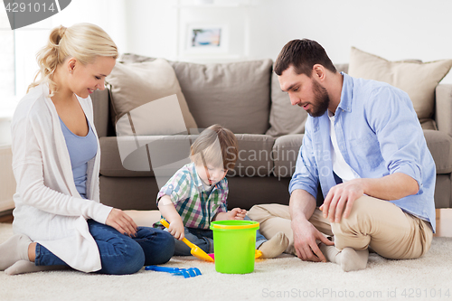 Image of happy family playing with beach toys at home