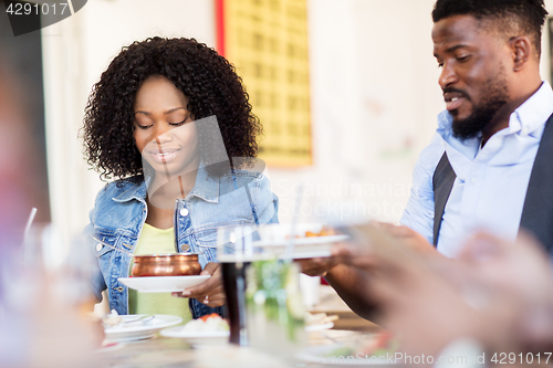 Image of happy man and woman eating at restaurant