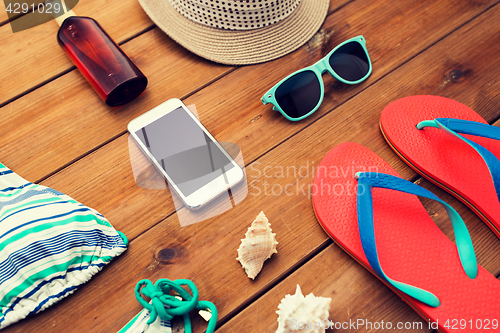 Image of close up of smartphone and beach stuff