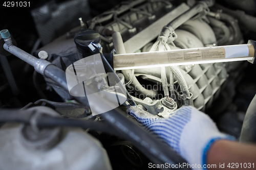 Image of mechanic man with wrench repairing car at workshop