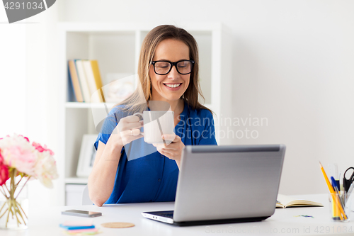 Image of woman with laptop and coffee at home or office