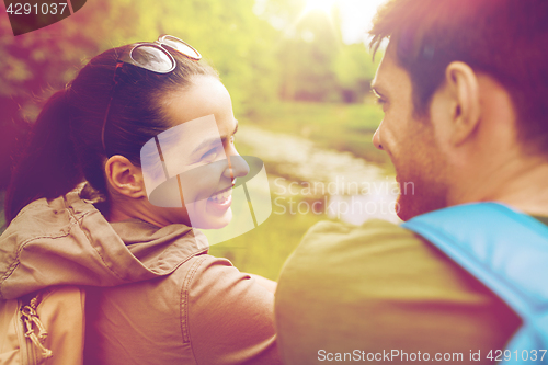 Image of smiling couple with backpacks in nature