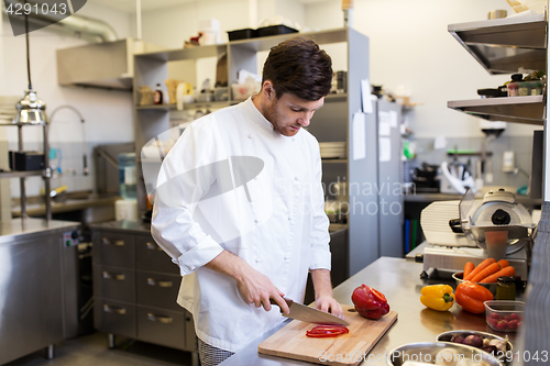 Image of happy male chef cooking food at restaurant kitchen