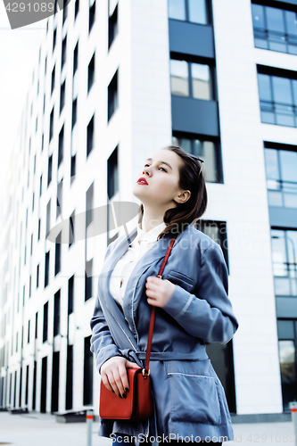 Image of young pretty brunette business woman posing against modern building, lifestyle people concept