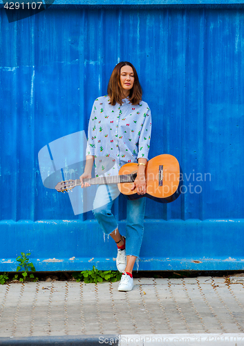 Image of fashion. Beautiful woman with a guitar