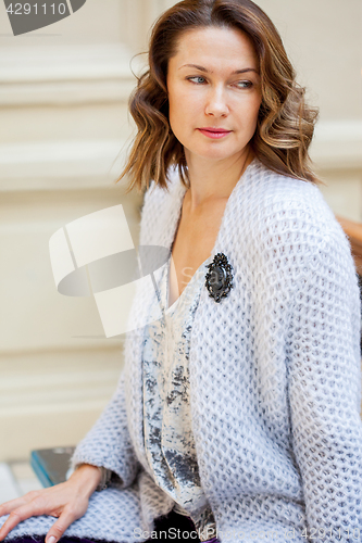 Image of beautiful woman in a light blue knitted coat