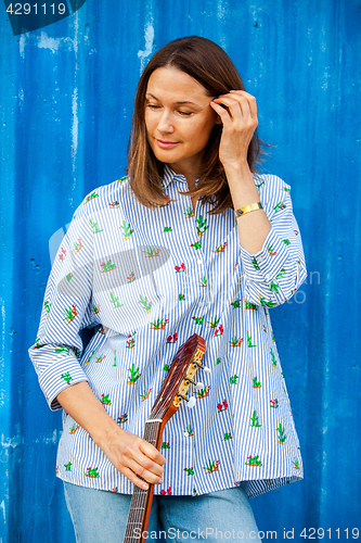 Image of Portrait of a beautiful smiling woman with a guitar 