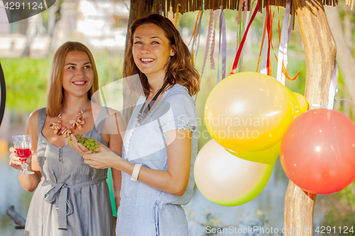 Image of Two beautiful cheerful women at a picnic