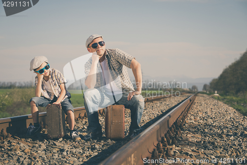 Image of Father and son walking on the railway at the day time.