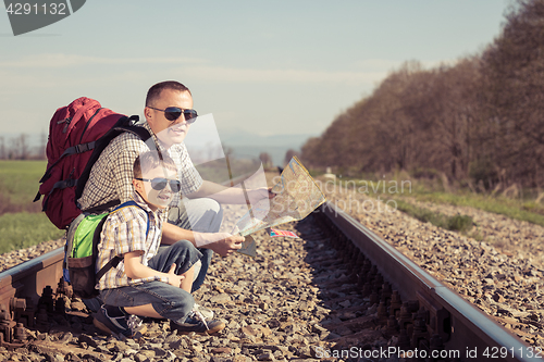 Image of Father and son walking on the railway at the day time.