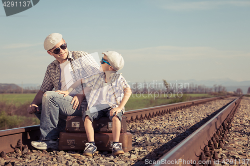 Image of Father and son walking on the railway at the day time. 