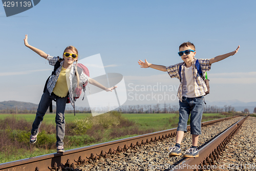 Image of Happy brother and sister walking on the railway at the day time.