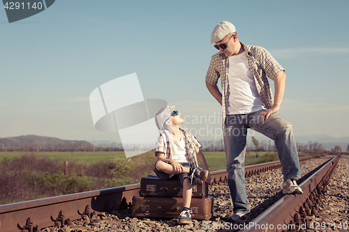 Image of Father and son walking on the railway at the day time.