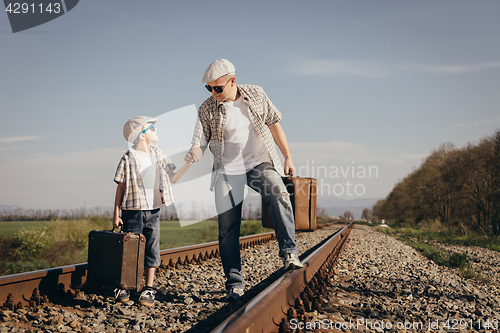 Image of Father and son walking on the railway at the day time.