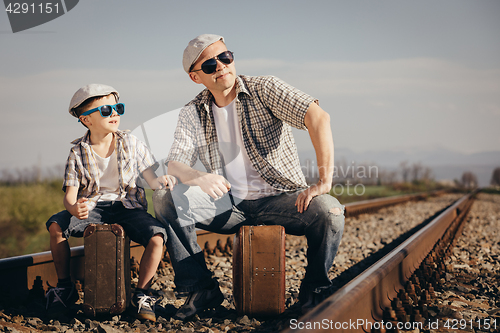 Image of Father and son walking on the railway at the day time.