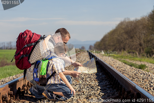 Image of Father and son walking on the railway at the day time.