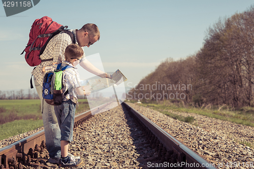 Image of Father and son walking on the railway at the day time.