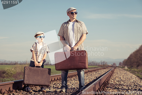 Image of Father and son walking on the railway at the day time.