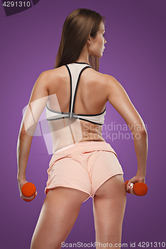 Image of Muscular young woman athlete posing at studio