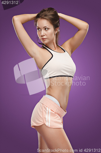 Image of Muscular young woman athlete posing at studio