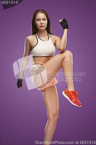 Image of Muscular young woman athlete posing at studio