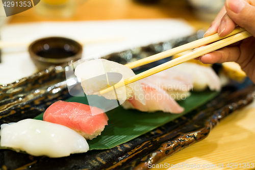 Image of Sushi with chopsticks