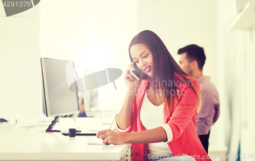 Image of businesswoman calling on smartphone at office