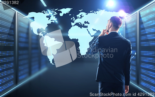 Image of businessman with world map projection in corridor