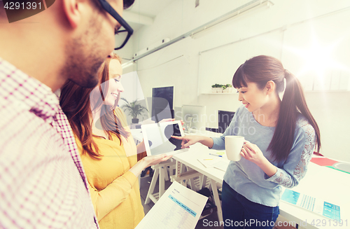 Image of creative team with tablet pc talking at office