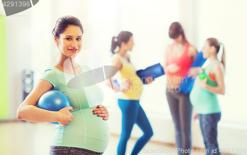 Image of happy pregnant woman with ball in gym